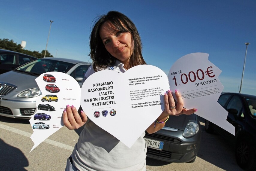 La Fiat impacchetta le auto "straniere" dei dipendenti apponendo un cuore spezzato. Sulle auto di marca FIAT viene messo un cuore intero.