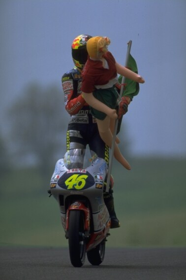 Con il pesarese, nel giro d’onore, una bionda gonfiabile vestita da Claudia “Skiffer”, storpiatura del nome ironicamente voluta, per prendere in giro Max Biaggi, allora già pilota in 500 che in quel periodo avrebbe avuto un flirt Naomi Campbell.