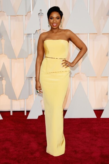 Sfila sul red carpet mostrando la sua forma smagliante e un tubino giallo di Romona Keveza essenziale e chic. Completano il look sandali Jimmy Choo