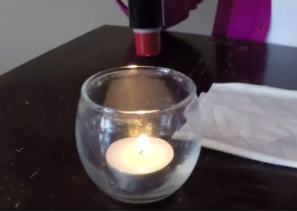 Posizionate la base del rossetto su una candela in modo da far sciogliere lo strato superficiale di cera.