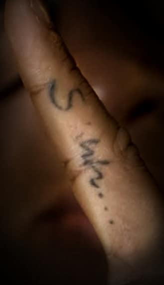 Tatuato sull'indice della mano, che indica il "silenzio". Tatuaggio visto e poi copiato alla cantante Rihanna