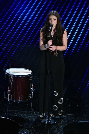 Tuta black con maxi occhi ricamati e sandalo con calzino in bella mostra per la Michelin che sfoggia un hair style morbido con onde.