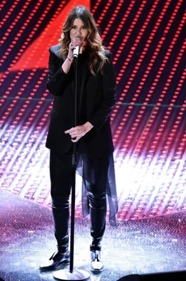 Giacca over size con coda, pantaloni skinny e stivaletti per la cantante che sceglie il total black anche in questa puntata