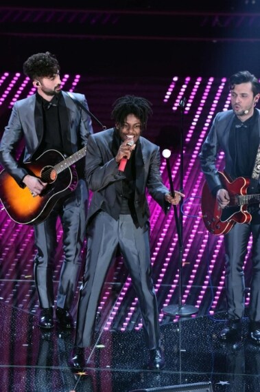 La band indossa ancora una volta abiti tutti uguali, in questo caso si tratta di frac in grigio con profili lucenti