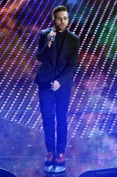 Total black spezzato da accecanti scarpe rosse, ecco il look del cantante