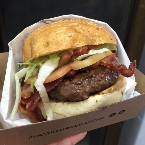 Bun con Hamburger, bacon croccante, insalata iceberg, pomodori e salsa Puok