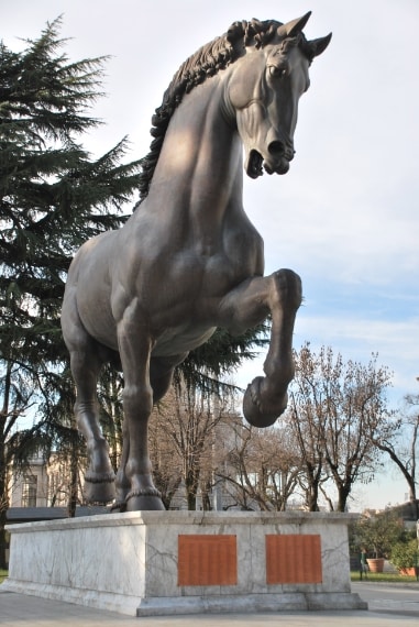 È un enorme cavallo di bronzo alto 7,20 m., lungo 8 e pesante 15 tonnellate. Ideato da Leonardo Da Vinci, la sua realizzazione ha richiesto 500 anni esatti. La storia comincia nel 1482, quando Ludovico il Moro incarica Leonardo di costruire “la più grande statua equestre del mondo” per rendere omaggio al padre. Solo nel 1999 il cavallo di bronzo vede la luce grazie alla scultrice Nina Akamu.