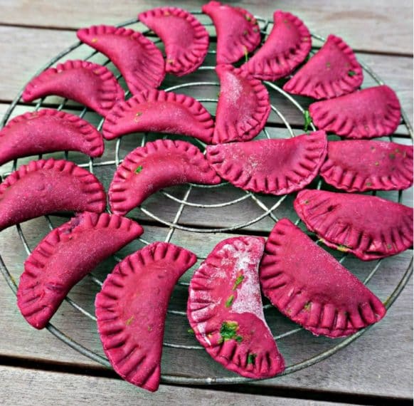 Gustosissimi ravioli al gusto di barbabietola e ripieni formaggio e spinaci. Fonte: https://belgianfoodie.com/recipe/red-beet-ravioli-spinach-goat-cheese/