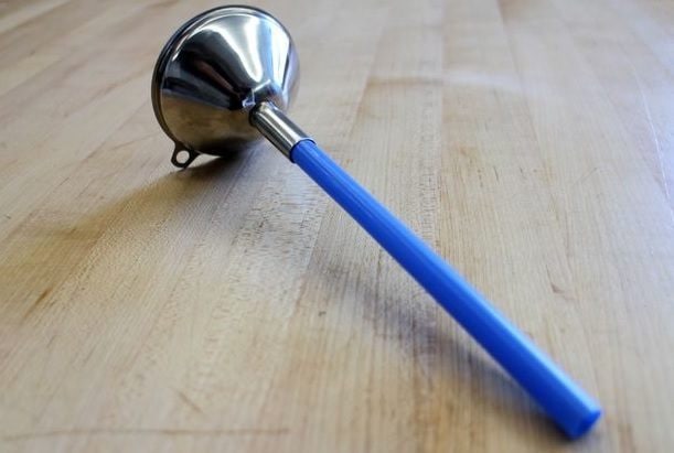 Funnels are really handy tools, but the wide top doesn't always fit into tight spaces. A straw can be a handy solution.