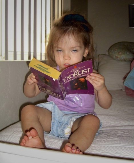 L'espressione della bimba che legge l'esorcista è tutta un programma