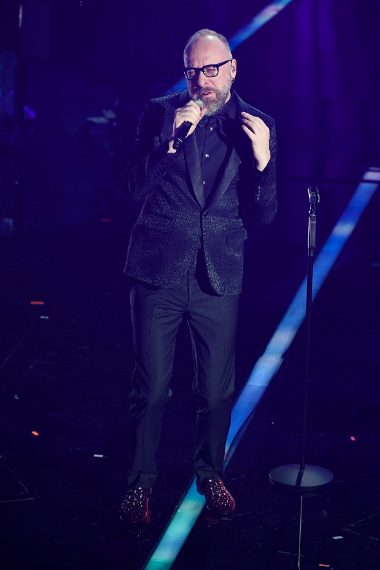 Look total black per il cantante, troppo nero e le scarpe (rosse e con cristalli) non migliorano la situazione. Voto 4 e 1/2