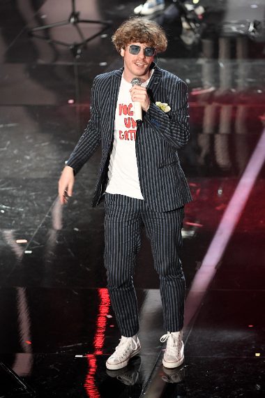 Occhiali colorati e T-shirt "Voglio un gattino" sotto abito gessato. Originali, moderni e ironici, praticamente perfetti. Voto 9