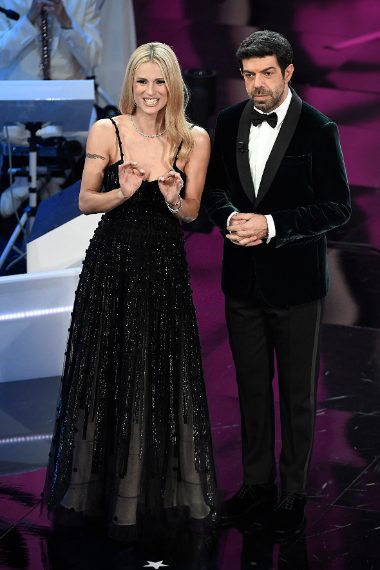 Elegantissimo nel suo splendido smoking in velluto verde scuro. Voto 9