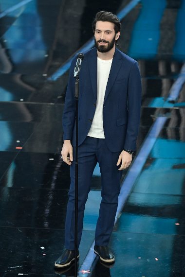 Abito blu su shirt bianca, convince il look (con barba lunga e incolta da hipster) moderno e cool del cantante. Voto 7 e 1/2
