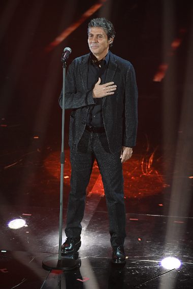 Il cantante sceglie un completo scuro indossato senza cravatta