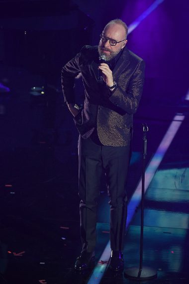 Giacca animalier e occhiali tondi per il cantante