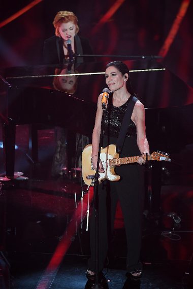 La Turci indossa una tuta con corpetto lavorato e abbina gioielli Damiani e scarpe Giuseppe Zanotti