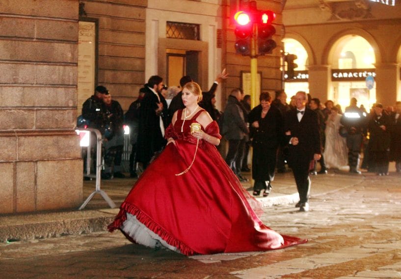Un'ospite raggiunge il teatro con un abito rosso dallo stile ottocentesco
