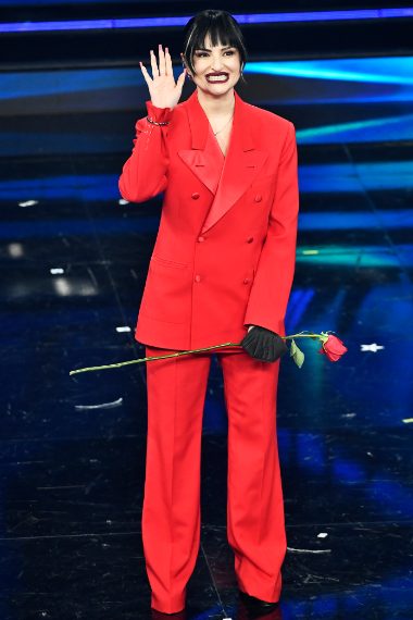 La cantante per la prima serata di Sanremo sceglie un look mannish con tailleur rosso fuoco