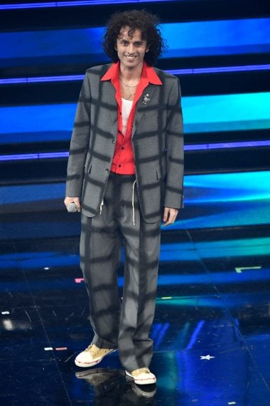 Il cantante sceglie un completo dalla fantasia geometrica su camicia rouge