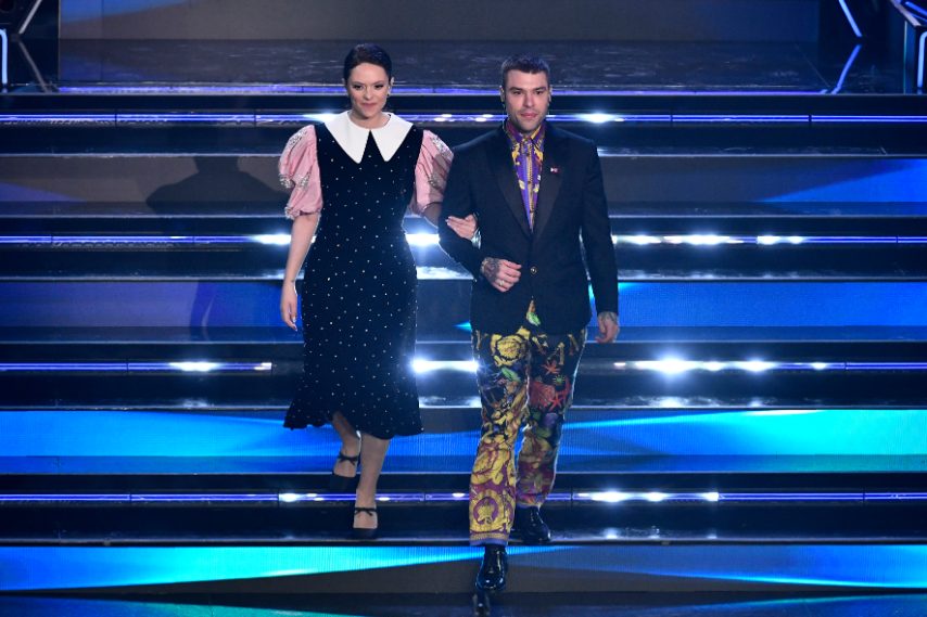 Lei indossa un abito nero con maxi maniche rosa, Fedez sceglie completo in seta a stampa su tuxedo total black