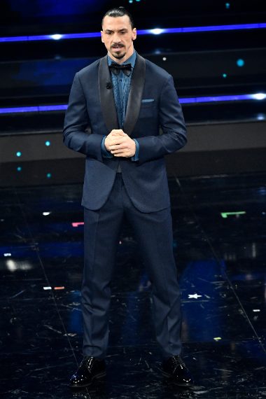 Il calciatore indossa uno smoking blu con rever neri a contrasto