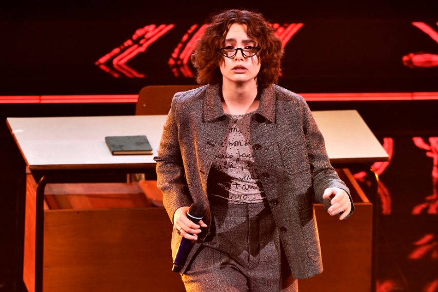 Con un tailleur grigio composto da giacca e pantaloni