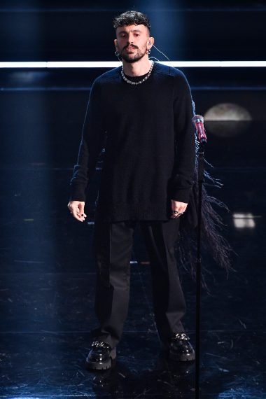 Il cantante indossa una particolare shirt con applicazione di piume sulla schiena