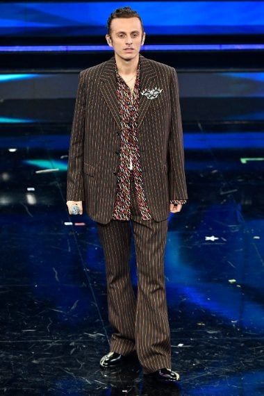 Completo gessato su camicia a stampa per il cantante