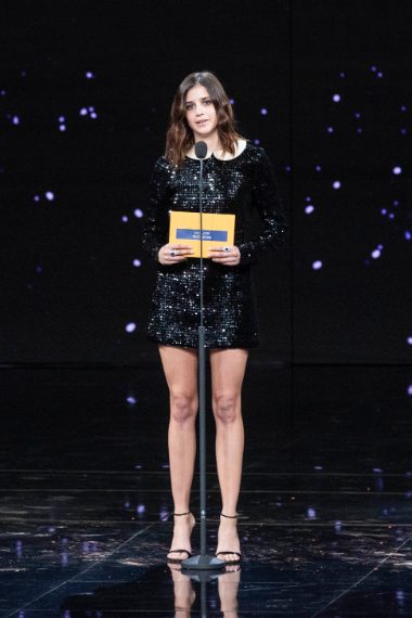 L'attrice sul palco con un abito corto nero con colletto e gioielli Bvlgari