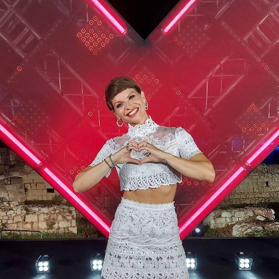 La cantante indossa un top e una gonna bianca di Ermanno Scervino