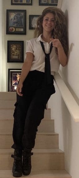 Shakira sulla scala di casa con la parete di premi