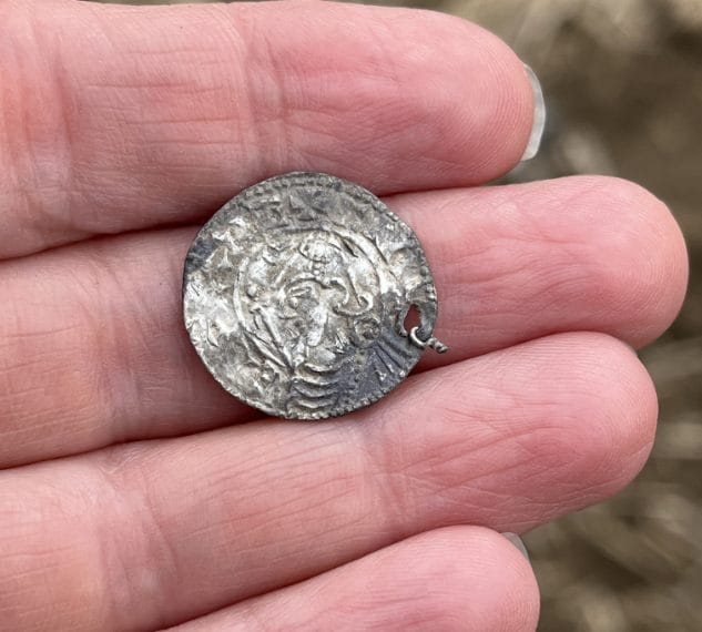 Una moneta con tracce di un appiccagnolo (occhiello di sospensione), a dimostrazione che veniva indossata come gioiello. La moneta fa parte del tesoro di Mørstad vicino a Rena. Foto: May-Tove Smiseth, Consiglio della Contea di Innlandet