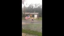 "Non ti temo": a petto nudo sfida l'uragano Matthew con una bandiera Usa