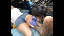 Il tatuaggio le occupa tutta la coscia: la ragazza in shorts sul lettino