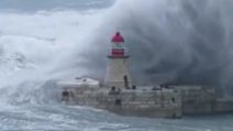 La tempesta si abbatte sulla città: il faro del porto sembra scomparire