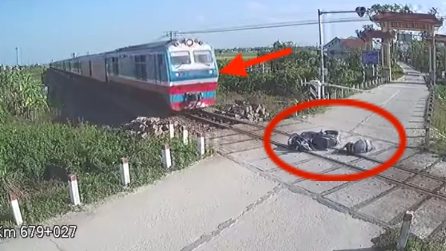 Cade con la moto e finisce sui binari mentre passa il treno
