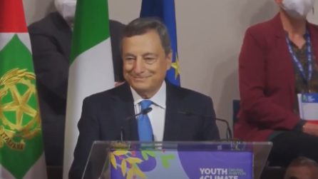 Mario Draghi sorride durante l'interruzione dei manifestanti allo Youth4Climate