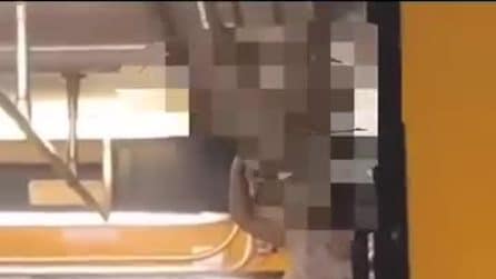 Ragazzina viaggia in treno in piedi sui sedili con la testa sul finestrino