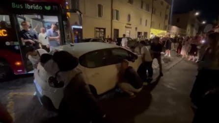 Bus bloccato da un’auto in sosta vietata a Roma, passeggeri e turisti la spostano a mano: il video